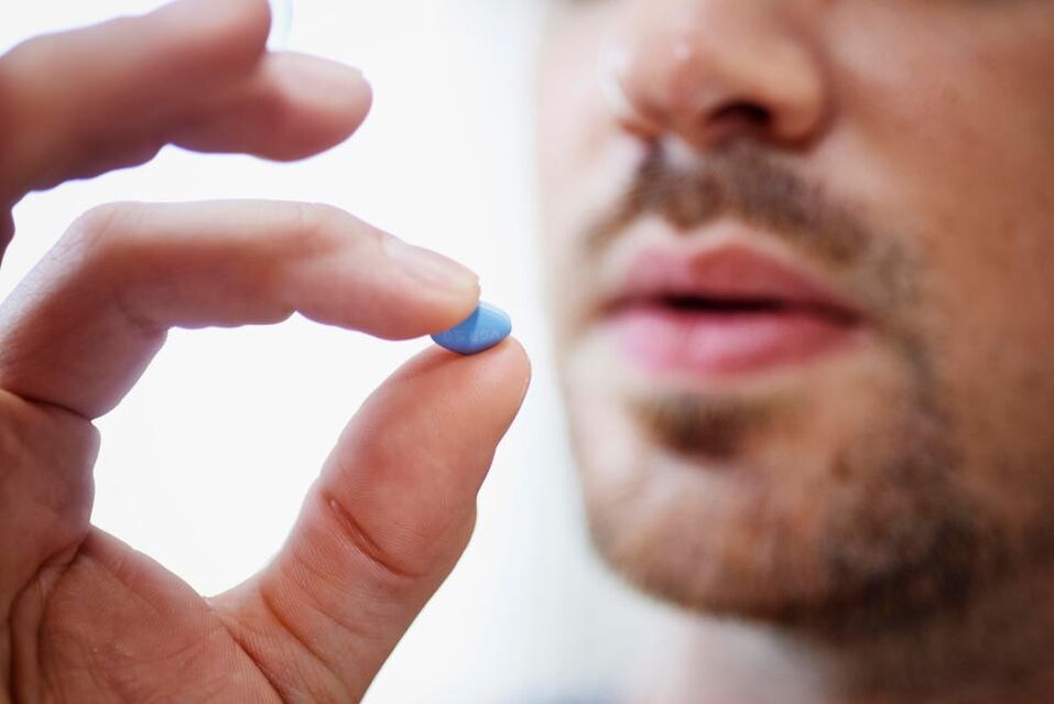 moški vzame tableto za spodbujanje moči